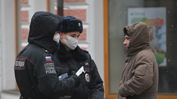 Сотрудники полиции проверяют документы прохожего на улице в Москве
