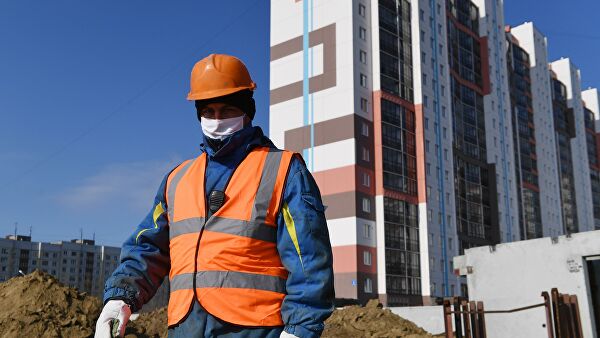 Рабочий в медицинской маске на строительстве жилого комплекса в Новосибирске