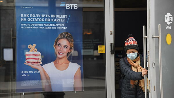 Посетитель выходит из отделения банка ВТБ на одной из улиц в Москве Посетитель выходит из отделения банка ВТБ на одной из улиц в Москве