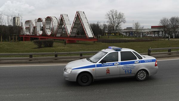 Автомобиль полиции проезжает мимо стелы на въезде в Москву