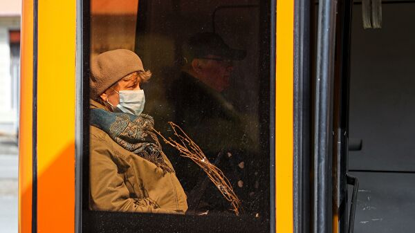 Женщина в защитной маске в салоне автобуса