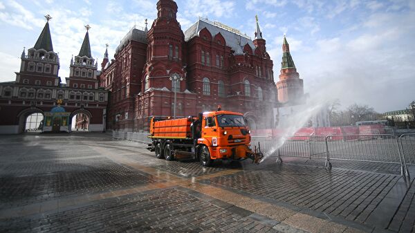 Автомобиль коммунальных служб дезинфицирует дороги и тротуары в центре Москвы.