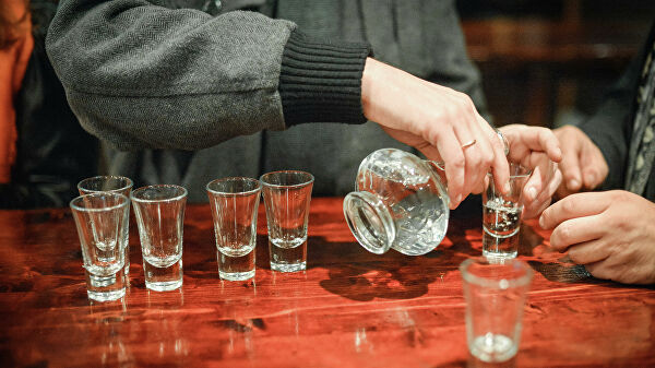 Посетитель разливает водку в пивном баре на Никольской улице в Москве