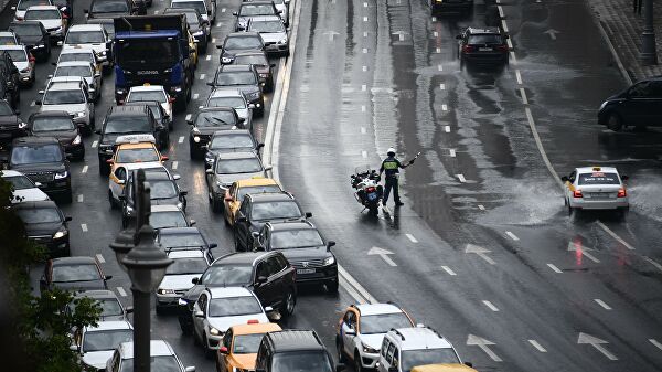 Сотрудник ДПС регулирует движение на Тверской улице в Москве в районе горящего здания