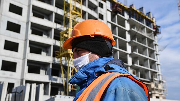Рабочий в медицинской маске на строительстве жилого комплекса в Новосибирске