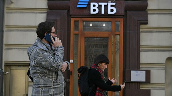 Прохожие у отделения банка ВТБ на одной из улиц в Москве