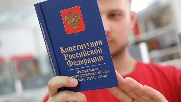 Молодой человек держит книгу конституции Российской Федерации 