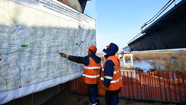 Рабочие осматривают план строительства четвертого пускового комплекса Центральной кольцевой автомобильной дороги в Москве