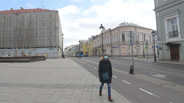 Девушка в защитной маске улице Большая Никитская в Москве