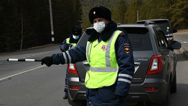 Сотрудник ДПС останавливает автомобиль для проверки Сотрудник ДПС останавливает автомобиль для проверки