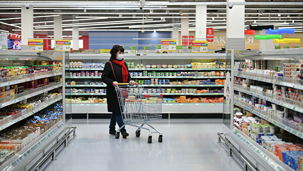Женщина в защитной маске покупает продукты в гипермаркете